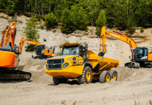 Hitachi grävmaskiner och Bell dumper arbetar i en grusgrop